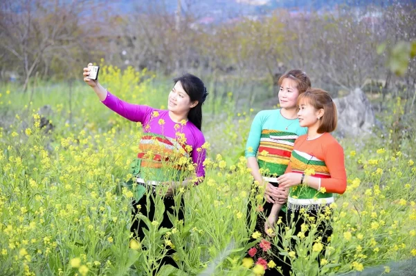 The image of Thai girls in traditional costume beside branches of wild peach blossoms
